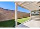 Private backyard oasis with a covered patio, artificial grass, and a brick wall, ideal for outdoor enjoyment at 532 Monarch Ridge Ct, North Las Vegas, NV 89084