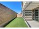 Low maintenance backyard with artificial grass, a brick wall, and a covered patio for comfortable outdoor living at 532 Monarch Ridge Ct, North Las Vegas, NV 89084