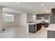 Bright, open-concept kitchen with a center island, stainless steel appliances, and tiled flooring at 532 Monarch Ridge Ct, North Las Vegas, NV 89084