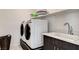 This laundry room features modern appliances, sink, and storage shelves at 532 Monarch Ridge Ct, North Las Vegas, NV 89084