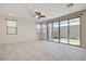 Spacious living room with tile flooring, a ceiling fan, and sliding glass doors leading to the backyard at 532 Monarch Ridge Ct, North Las Vegas, NV 89084
