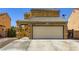 A home featuring a two-car garage and landscaped front yard at 5754 Cinnabar Ave, Las Vegas, NV 89110