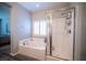 Bright bathroom features a soaking tub, separate glass shower, and tiled walls creating a fresh, clean space at 7252 Blowing Breeze Ave, Las Vegas, NV 89179