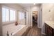 Bathroom featuring a soaking tub, glass shower, and wood-look floors that create a spa-like environment at 7252 Blowing Breeze Ave, Las Vegas, NV 89179