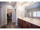 Bathroom boasts dual sinks, a glass shower, a walk-in closet, and modern wood-look floors at 7252 Blowing Breeze Ave, Las Vegas, NV 89179