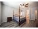 Comfortable bedroom with a wooden four-poster bed, ceiling fan, neutral paint, and modern wood-look floors at 7252 Blowing Breeze Ave, Las Vegas, NV 89179