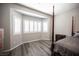 Bright bedroom featuring a large window with white shutters and neutral paint, creating a serene atmosphere at 7252 Blowing Breeze Ave, Las Vegas, NV 89179