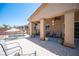 Covered outdoor patio with stylish seating, ceiling fan, and views of the pool area at 7252 Blowing Breeze Ave, Las Vegas, NV 89179