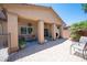 Inviting covered patio featuring ample seating, potted plants, and a view of the backyard at 7252 Blowing Breeze Ave, Las Vegas, NV 89179