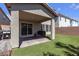 A backyard features artificial turf, a covered patio, and a brick perimeter wall at 7960 Calito St, Las Vegas, NV 89166