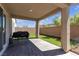 Covered patio with brick pavers in a backyard with artificial turf, perfect for outdoor dining and relaxation at 7960 Calito St, Las Vegas, NV 89166