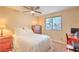 Well-lit bedroom with a window view, ceiling fan, and desk area at 8737 Autumn Valley Ave, Las Vegas, NV 89129