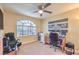 A carpeted bedroom featuring a ceiling fan, natural light, and a view of palm trees at 8737 Autumn Valley Ave, Las Vegas, NV 89129