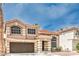 Charming home exterior featuring a two-car garage, red tile roof, an arched window and well-maintained landscaping at 8737 Autumn Valley Ave, Las Vegas, NV 89129