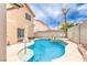 Private backyard oasis with a sparkling pool and spa, surrounded by lush landscaping and mature palm trees at 8737 Autumn Valley Ave, Las Vegas, NV 89129