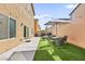 A low maintenance backyard features artificial grass and an outdoor dining area at 8937 Pelican Point St, Las Vegas, NV 89178