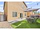 Outdoor patio with turf, garden bed, furniture, string lights, and a built-in grill at 8937 Pelican Point St, Las Vegas, NV 89178