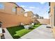 Landscaped backyard with a patio, artificial turf, seating, and string lights at 8937 Pelican Point St, Las Vegas, NV 89178