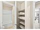 Bathroom closet with shelves, featuring towels and a glimpse into the ensuite shower/tub at 8937 Pelican Point St, Las Vegas, NV 89178