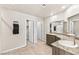 Bright bathroom featuring double sinks, granite counters, and neutral tile floors at 8937 Pelican Point St, Las Vegas, NV 89178