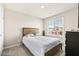 Bright bedroom with neutral walls, a window, and a wooden bed frame at 8937 Pelican Point St, Las Vegas, NV 89178