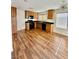 Well-lit kitchen featuring wood floors, modern appliances, wood cabinets, and a stylish light fixture at 12021 Spice Tree St, Las Vegas, NV 89183