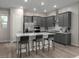 Modern kitchen featuring stainless steel appliances, gray cabinets, and a central island with bar stools at 1556 Pacific Baza St, Las Vegas, NV 89138