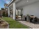 Covered outdoor patio with a dining area and beautifully landscaped backyard at 1556 Pacific Baza St, Las Vegas, NV 89138