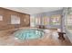 Indoor hot tub area featuring tile flooring, benches, and bright natural light near a 