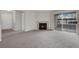 Open living room with fireplace, gray carpet, and balcony access via sliding glass doors at 2200 S Fort Apache Rd # 1101, Las Vegas, NV 89117