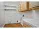 Bright laundry room features wood flooring, white shelving, and cabinetry at 2204 Ambermill Ct, Henderson, NV 89052