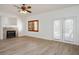 Bright living room featuring hardwood floors, a cozy fireplace, and double doors to the exterior at 2204 Ambermill Ct, Henderson, NV 89052