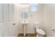 Powder room features pedestal sink, tile flooring, and natural light at 2400 Dutchmans Pipe Ct, Las Vegas, NV 89106