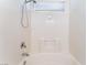 Well-lit bathroom featuring a clean, white bathtub with a built-in seat and shower head at 2400 Dutchmans Pipe Ct, Las Vegas, NV 89106