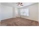 The bedroom has a large window, a ceiling fan, and neutral carpeting at 2400 Dutchmans Pipe Ct, Las Vegas, NV 89106