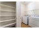 Bright laundry room with white washer, dryer and shelving for optimal storage space at 2400 Dutchmans Pipe Ct, Las Vegas, NV 89106