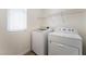 Bright laundry room featuring white washer and dryer, as well as an overhead rack for storage at 2400 Dutchmans Pipe Ct, Las Vegas, NV 89106