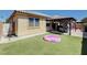 Backyard with a covered patio, artificial grass and a small inflatable pool at 5929 Caddy Ridge St, North Las Vegas, NV 89031