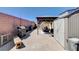 An expansive backyard patio featuring brick pavers, a grill, storage shed and a covered seating area at 5929 Caddy Ridge St, North Las Vegas, NV 89031