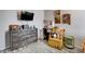 Cozy bedroom featuring a wooden dresser, workstation, and a comfortable yellow armchair at 5929 Caddy Ridge St, North Las Vegas, NV 89031
