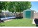 Backyard featuring a storage shed, synthetic grass, and a cinderblock fence at 6236 Foothill Blvd, Las Vegas, NV 89118