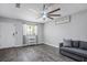 A living room featuring a modern ceiling fan, neutral paint, and gray wood floors at 6236 Foothill Blvd, Las Vegas, NV 89118