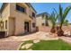 Backyard showcasing a stone patio, green grass and palm trees in a desert landscape at 6548 Butterfly Sky St, North Las Vegas, NV 89084