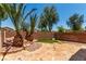 Landscaped backyard with stone patio, artificial turf, and mature trees for serene outdoor living at 6548 Butterfly Sky St, North Las Vegas, NV 89084