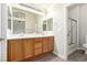 Bright bathroom featuring a double sink vanity and a shower over tub combo with glass doors at 6548 Butterfly Sky St, North Las Vegas, NV 89084
