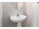 Compact half-bath featuring a stylish pedestal sink and modern fixtures at 6548 Butterfly Sky St, North Las Vegas, NV 89084