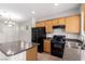 Well-lit kitchen featuring practical layout and black appliances at 6548 Butterfly Sky St, North Las Vegas, NV 89084