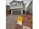 Two-story home featuring gray stucco, stone accents, a two-car garage, and drought-resistant landscaping at 6604 Bowery St, Las Vegas, NV 89148