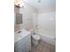Bright bathroom featuring a vanity with drawers, tub with white tiled surround and neutral wall color at 860 Bergamont Dr, Henderson, NV 89002