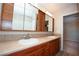 Bathroom featuring double sinks, ample cabinet space, a large mirror and neutral countertops at 860 Bergamont Dr, Henderson, NV 89002